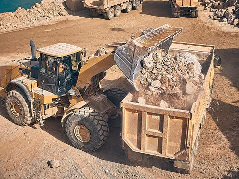 Wheel loader loads a truck on a mining site - Equipment for mining 