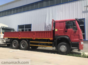 A 6x4 Sinotruk Cargo Truck in Red parked outside a warehouse of Camamach